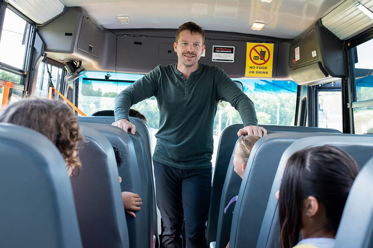 school bus attendant standing up at the front of the bus